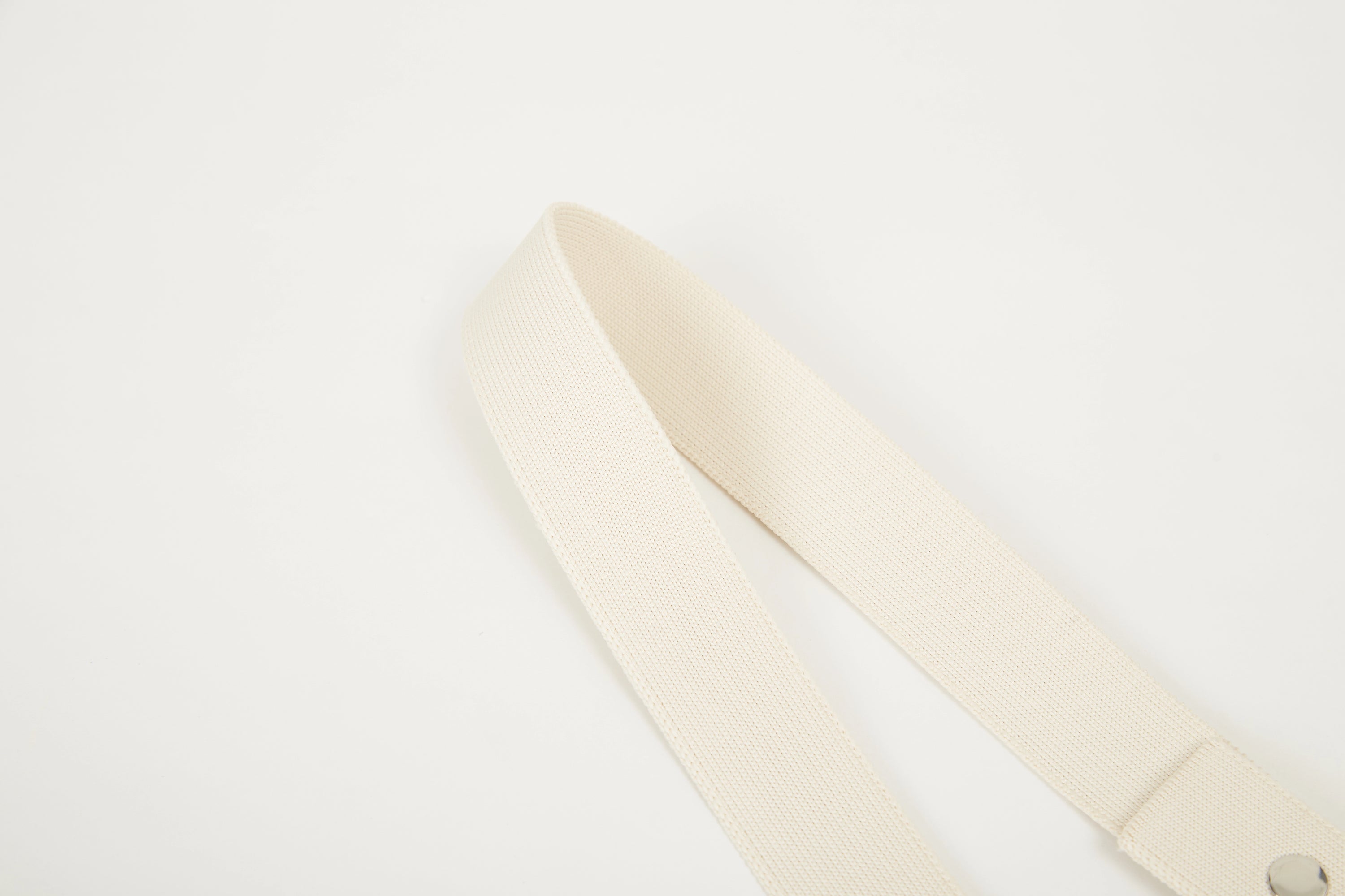 Close-up of beige Colorway Strap showing woven texture and metal snap details.