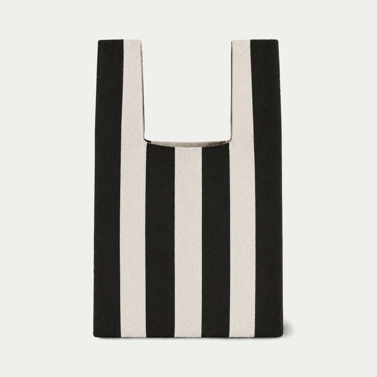 Black and white vertical stripe knitted tote bag featuring a bold striped design, a lightweight everyday bag made from recycled polyester yarn.