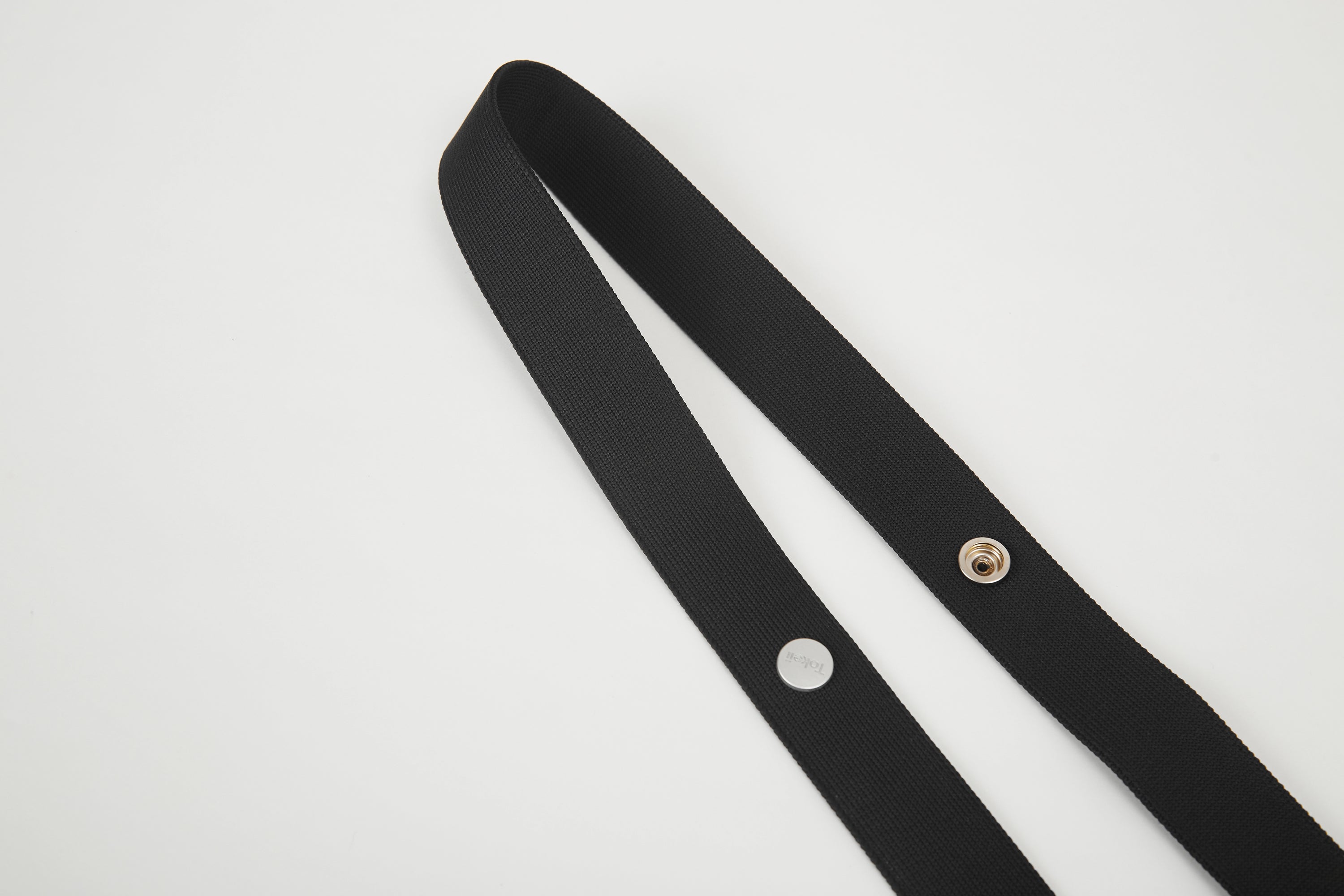 Close-up of black Colorway Strap showing woven texture and metal snap details.