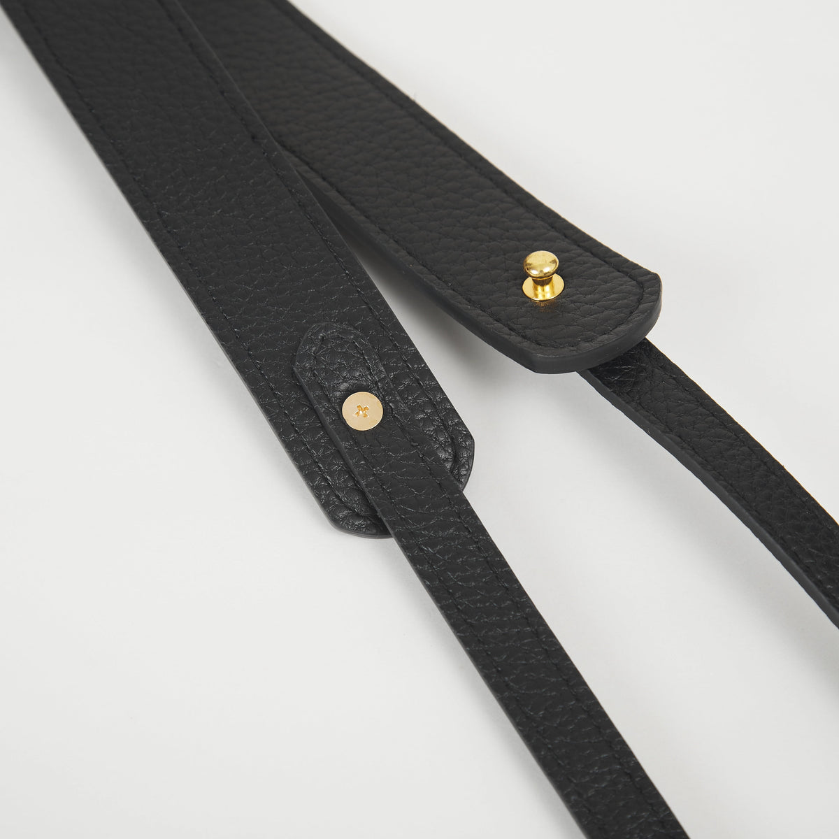 Close-up of beige faux leather Colorway Strap showing stitched edges and snap button details.