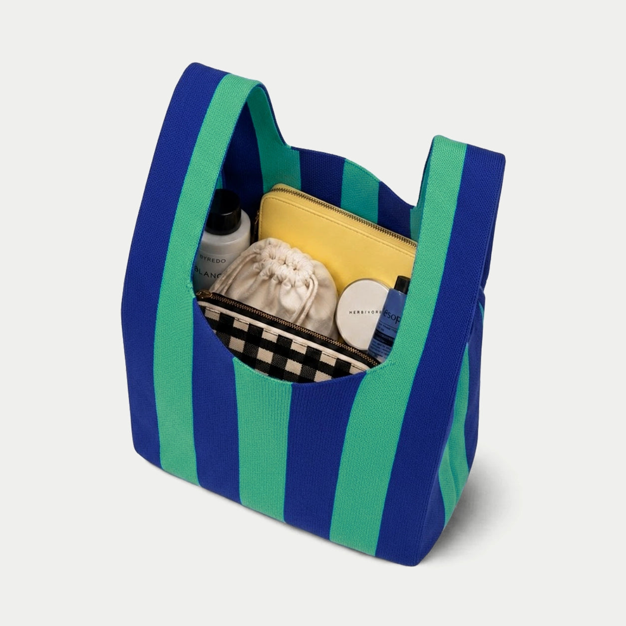 Blue and green vertical stripe knitted tote bag showing the spacious interior and capacity for carrying everyday essentials with its soft knitted construction.