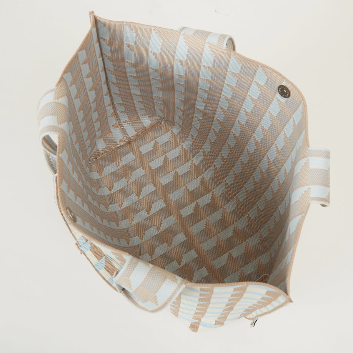 Top view of geometric check knitted tote bag showing open interior and snap closure.