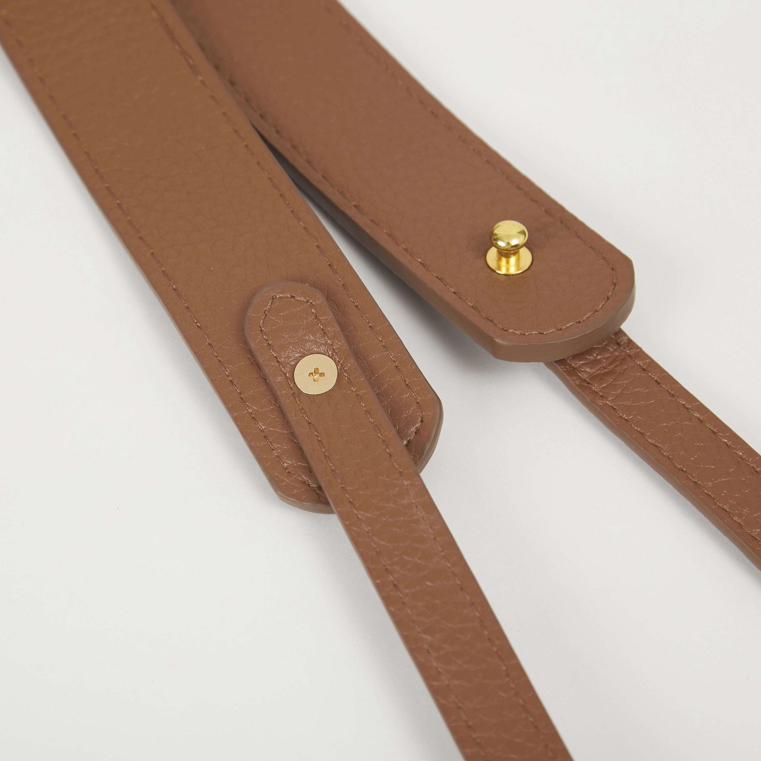 Close-up of brown faux leather Colorway Strap showing stitched edges and snap button details.