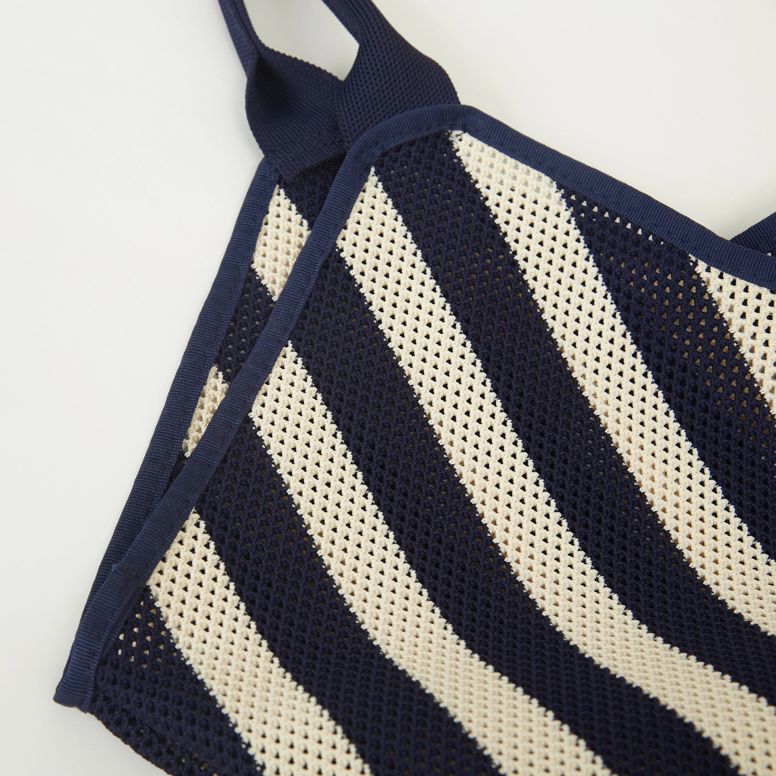 Detail view of navy and beige striped mesh knit tote bag highlighting the vertical stripe pattern and airy open knit structure.