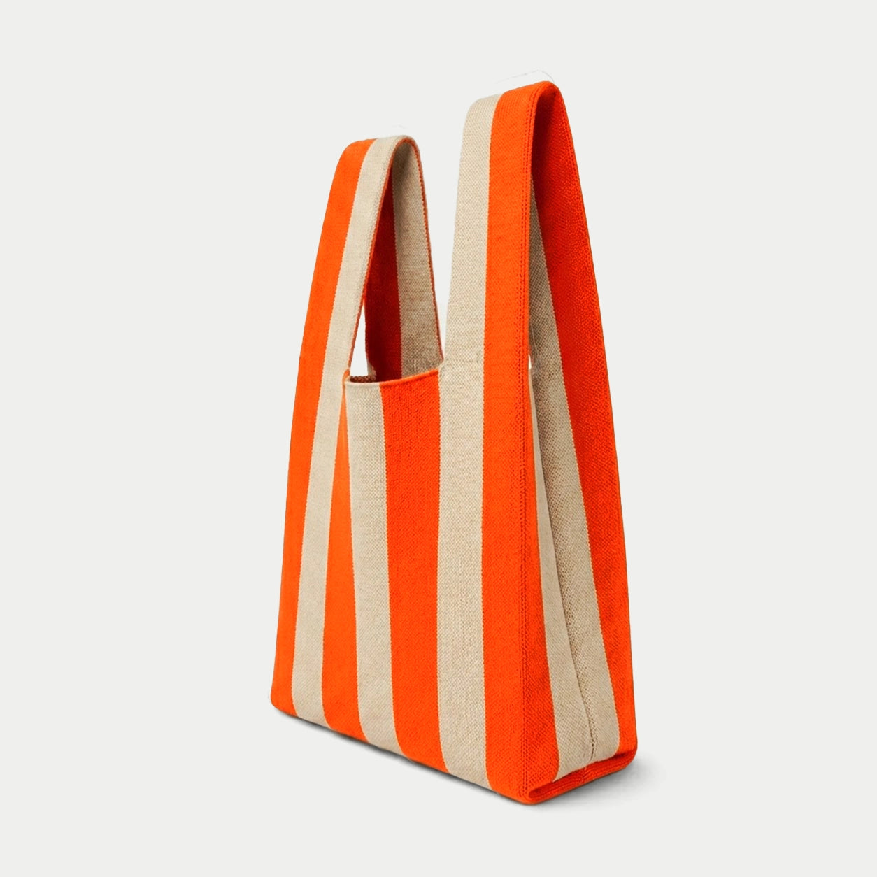 Side view of orange vertical stripe knitted tote bag showing the structured silhouette, handle design and textured knit construction.