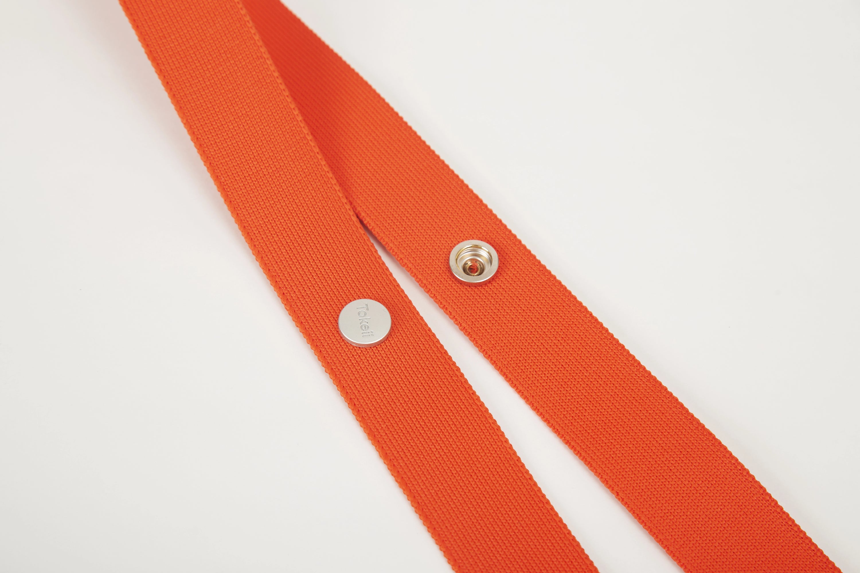 Orange Colorway Strap detail with Tokeii logo hardware and snap buttons.