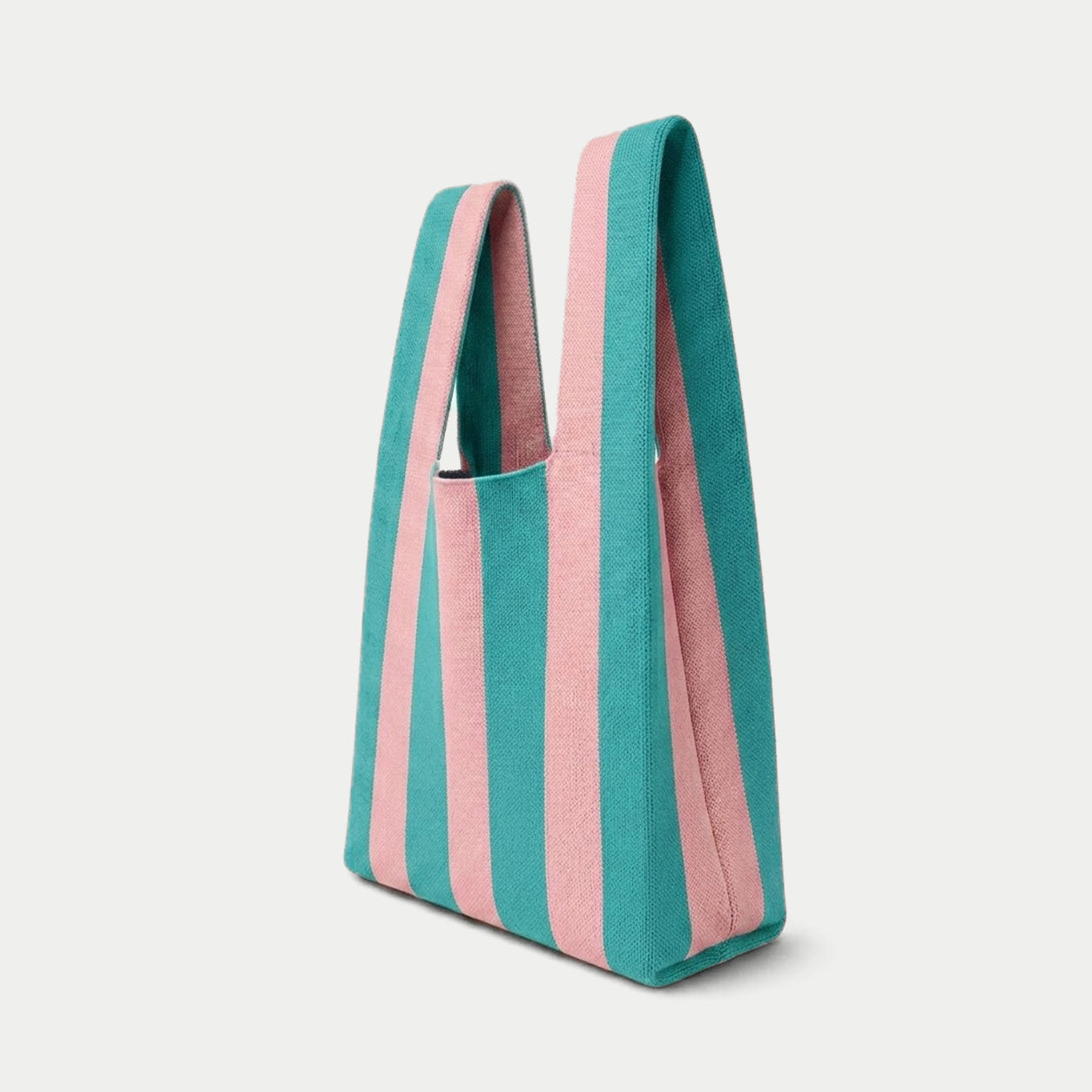 Side view of blue and pink vertical stripe knitted tote bag showing the structured silhouette, handle design and textured knit construction.