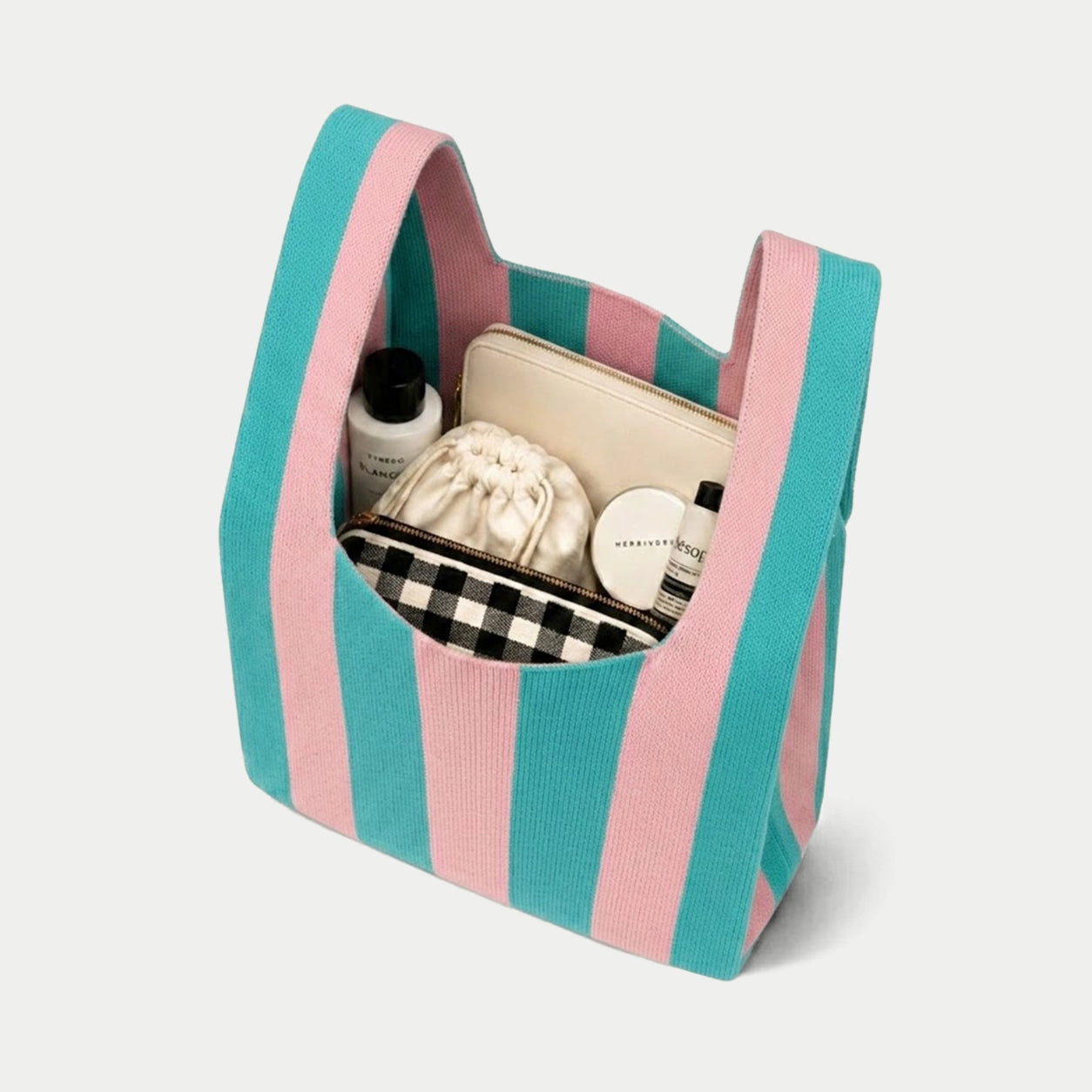 Blue and pink vertical stripe knitted tote bag showing the spacious interior and capacity for carrying everyday essentials with its soft knitted construction.
