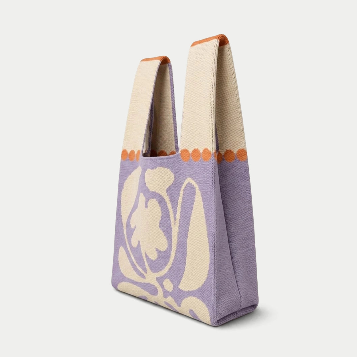 Side view of purple oversized flower knitted tote bag showing the structured silhouette, handle design and textured knit construction.