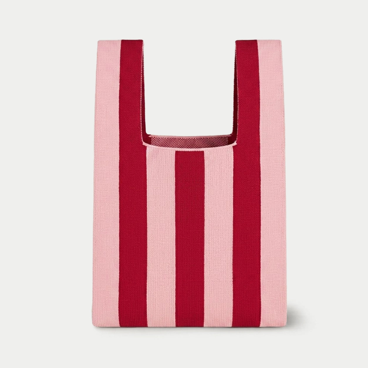 Pink and red vertical stripe knitted tote bag featuring a bold striped design, a lightweight everyday bag made from recycled polyester yarn.