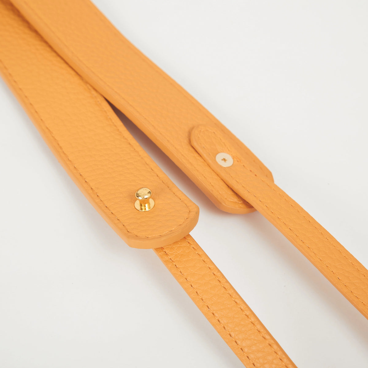 Close-up of yellow faux leather Colorway Strap showing stitched edges and snap button details.