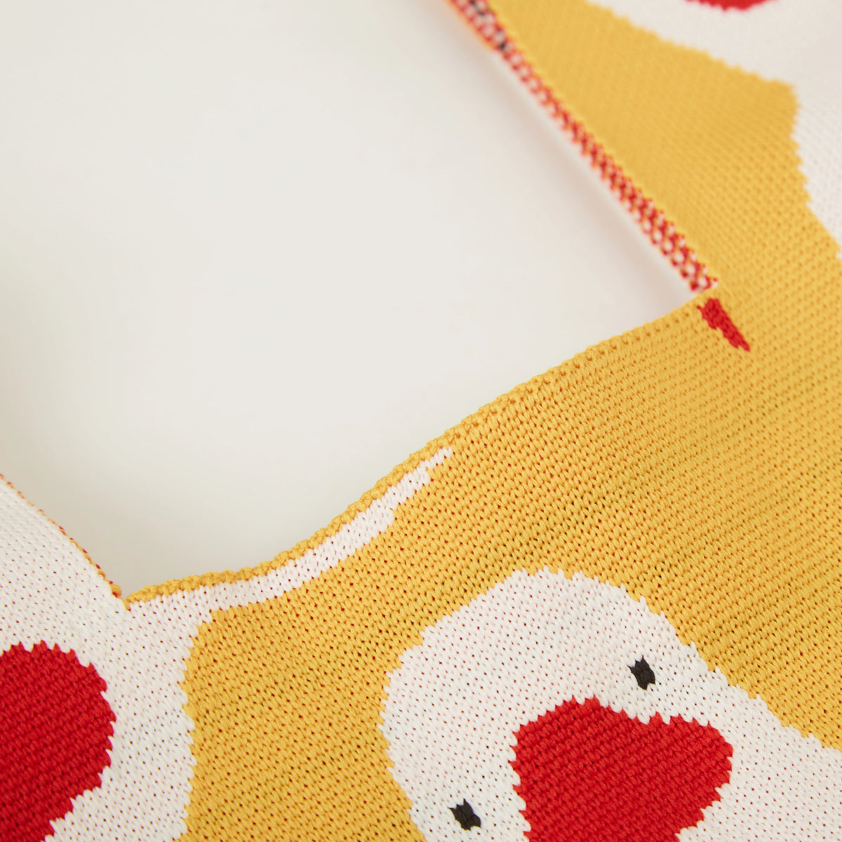 Close-up of yellow duck knit tote bag showing the graphic duck pattern, woven knit texture, and colorful design details.