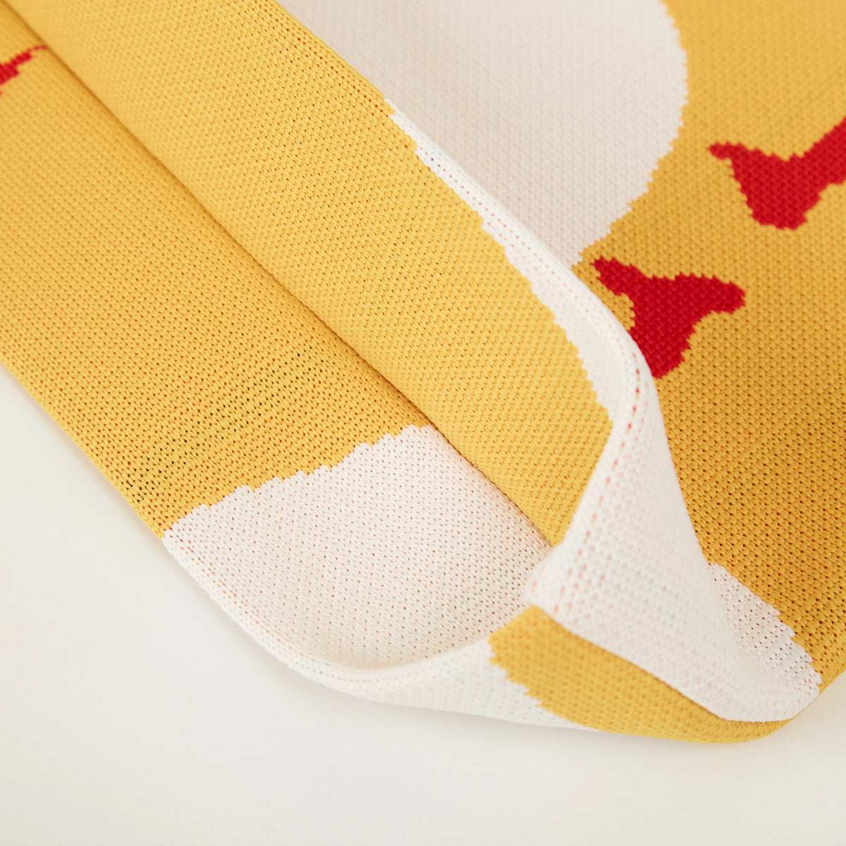 Detail view of yellow duck pattern knit tote bag edge.