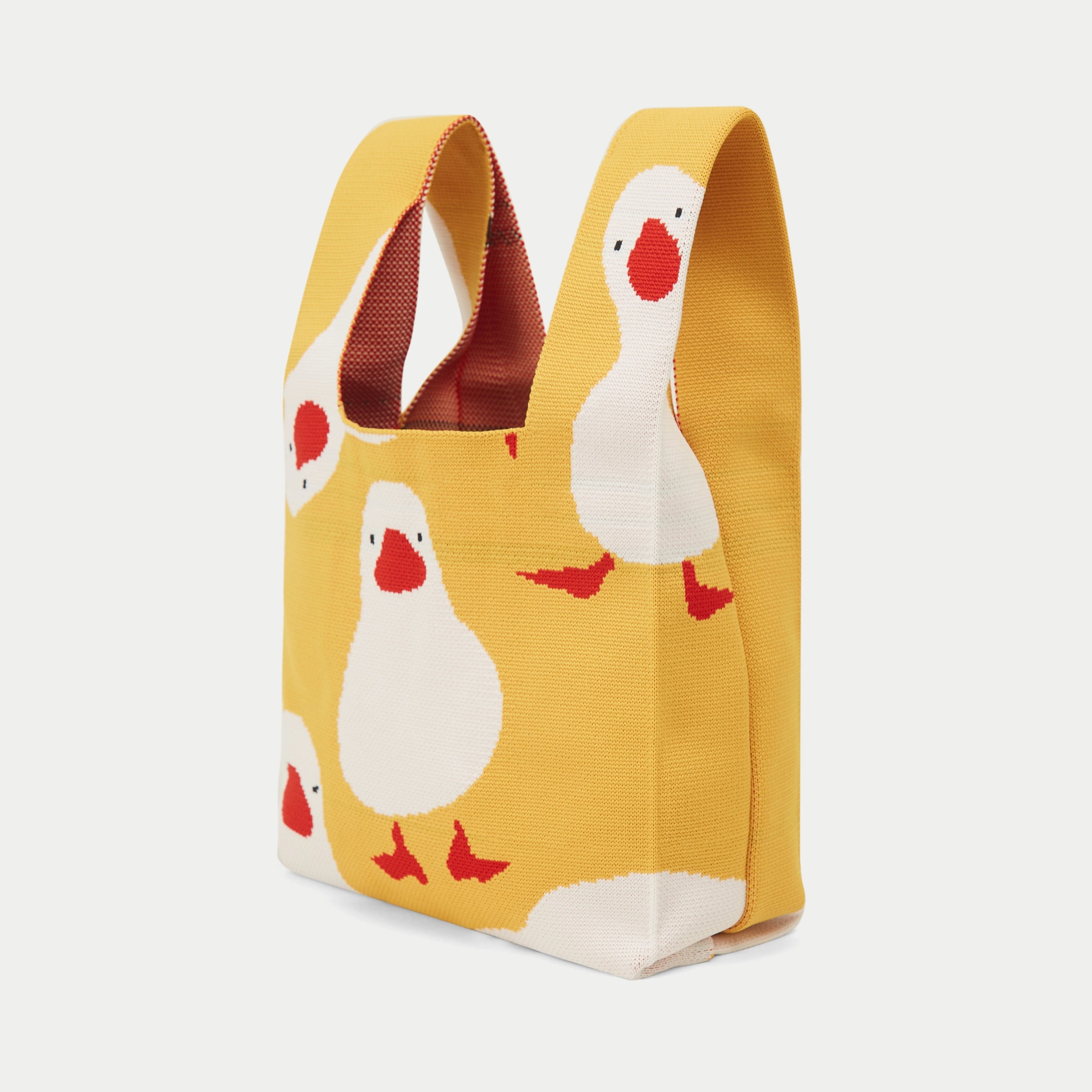 Side view of yellow duck pattern knit tote bag showing the soft knitted construction.