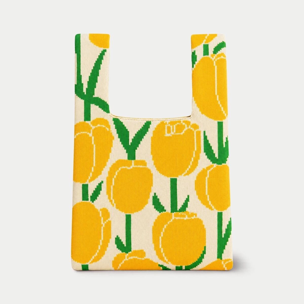 Yellow, cream and green tulip pattern knitted tote bag featuring oversized tulip flowers with contrasting stems and leaves, made from recycled polyester yarn by Tokeii.
