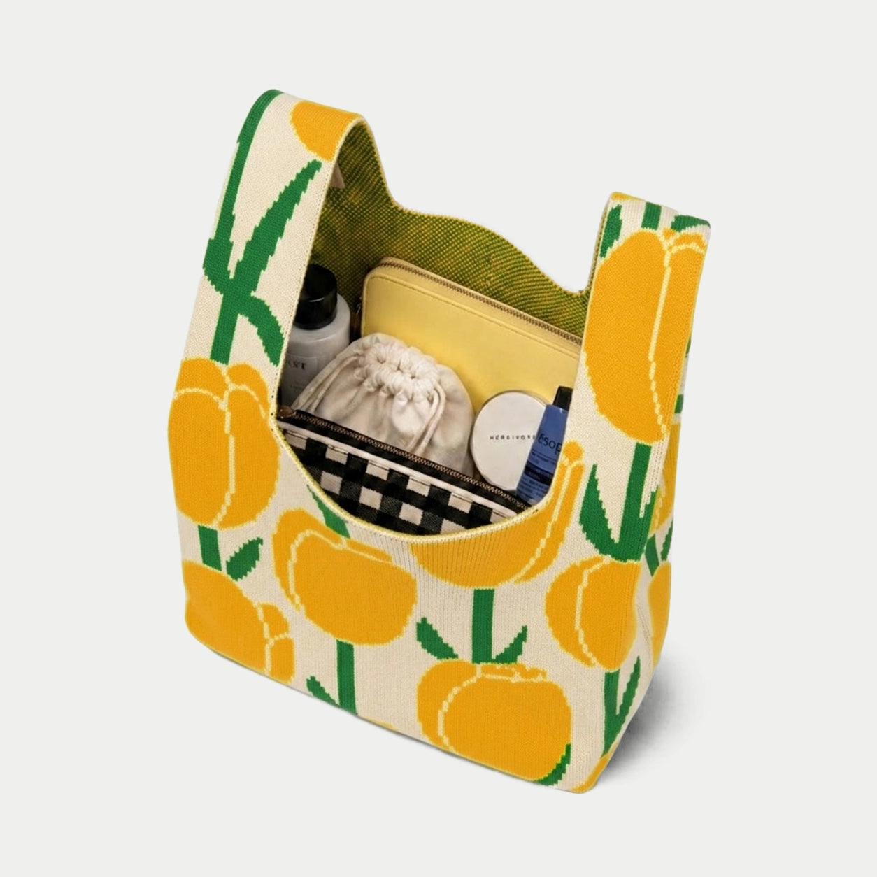 Top view of yellow, cream and green tulip pattern knitted tote bag showing its practical capacity for carrying cosmetics, pouches and everyday essentials.