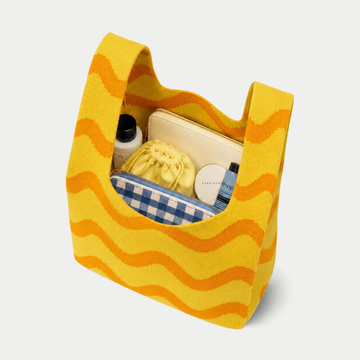Yellow Wave Pattern Knit Tote Bag shown open and filled with everyday essentials, highlighting its spacious knitted interior.